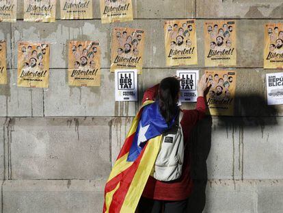Un joven pega carteles en Barcelona para pedir la libertad de los ocho exconsellers encarcelados 