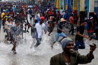 Partidaris del partit polític Fanmi Lavalas xipollegen per l'aigua en un carrer inundat i participen d'una trobada mentre l'huracà Matthew passa per Port-au-Prince (Haití).