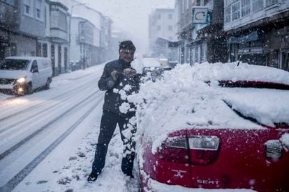 Un hombre quita la nieve de su coche en Castro Caldelas (Ourense), este miércoles. El 112 ha registrado desde la medianoche del lunes hasta las 6 horas de este miércoles 1.277 incidencias vinculadas al el temporal en Galicia.