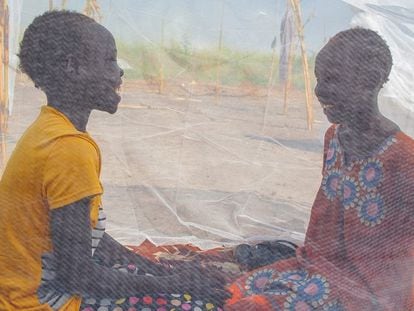 Unas adolescentes charlan protegidas por una mosquitera en Sudán del Sur.