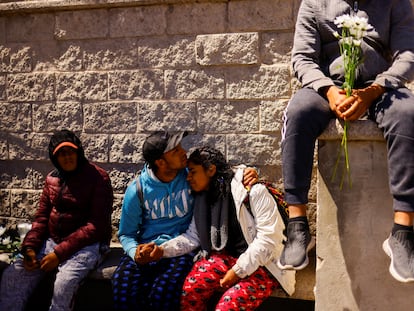 Migrants embrace as they sit with others during a protest outside the National Institute of Migration building after a fire broke out late on Monday at a migrant detention center, in Ciudad Juarez, Mexico, March 28, 2023. REUTERS/Jose Luis Gonzalez