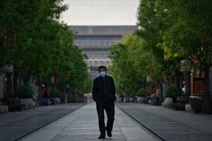 Un hombre en mascarilla pasea por la zona comercial de Qianmen, habitualmente muy concurrida, en el centro de Pekín