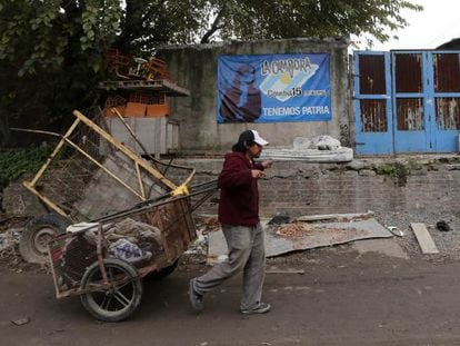 Un hombre empuja una carretilla en el barrio de La Carbonilla.