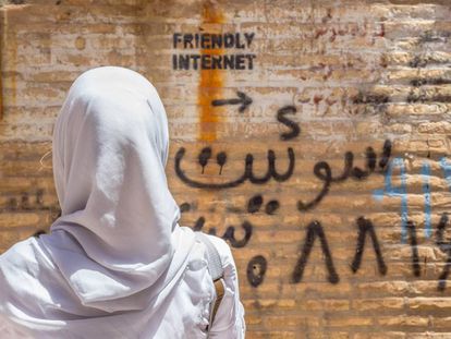Una mujer observa una pintada que indica un lugar con internet sin censura en Irán.