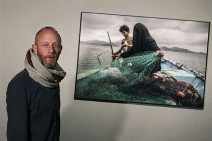 Pablo Tosco, premiado en el World Press Photo 2021 en la categoría de Asuntos contemporáneos, posa junto a su fotografía sobre Fátima de Yemen, en la exposición del CCCB.