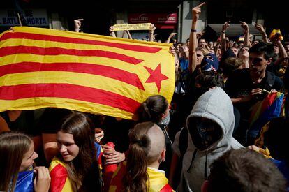 Un grupo de estudiantes sostiene una bandera estelada durante la manifestación en el centro de Barcelona celebrada este lunes para conmemorar el 1 de Octubre.