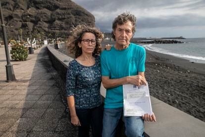 Joanna Arreaza y Martin Hohwalter, en el puerto de Tazacorte, posan junto a las escrituras de la casa que han perdido.