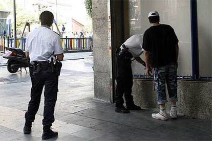 Dos policías identifican a un hombre en los soportales de la plaza de Soledad Torres Acosta.