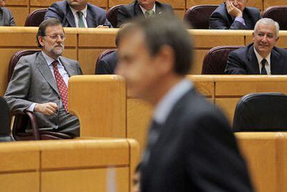 El presidente José Luis Rodríguez Zapatero pasa delante de Mariano Rajoy ayer en el Senado.