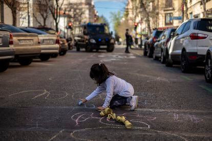 Una niña pinta en la calzada en la protesta junto al colegio Fernando el Católico, en Madrid. 
