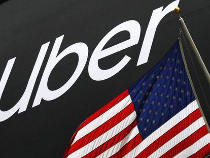 El logo de Uber junto a una bandera de Estados Unidos frente a la Bolsa de Nueva York. 