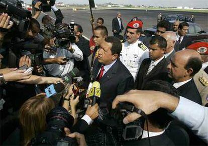 El presidente de Venezuela, Hugo Chávez, atiende a la prensa enel aeropuerto de La Habana, tras ser recibido por el vicepresidente cubano, Carlos Lage (derecha)