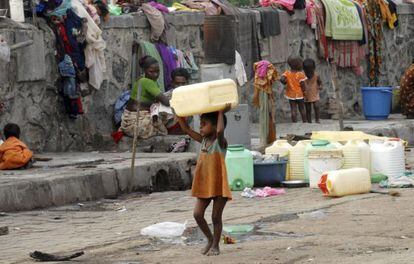 Una ni&ntilde;a carga con un bid&oacute;n para el agua en Bombai (India)