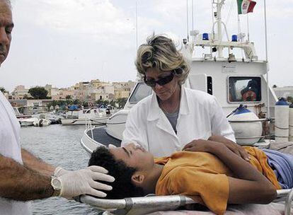 Unos médicos atienden a un <i>sin papeles </i> en la isla de Lampedusa.