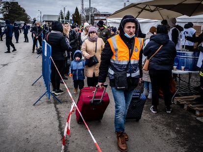 Pavlo Komarnitskii (al frente), con un grupo de refugiados ucranios, este domingo en el puesto fronterizo con Ucrania de Siret, en Rumania.