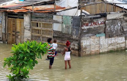 Una pareja conversa en uno de los barrios inundados de la periferia de Cartagena tras el paso del huracán Iota.