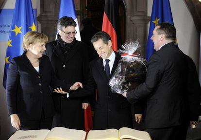 Sarkozy recibe un regalo de Merkel tras firmar el acuerdo entre ambos países para avanzar en una política de impuestos y laboral común.