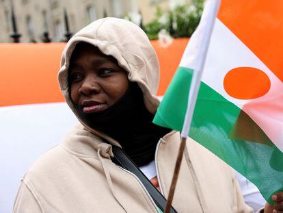 Una persona sostiene una bandera nigerina frente a la embajada de Níger en París, en apoyo al presidente de Mohamed Bazoum el sábado pasado.