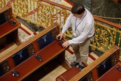 Un técnico coloca los auriculares de traducción en el hemiciclo del Congreso de los Diputados, este martes.
