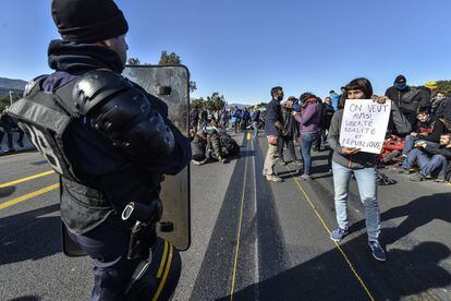 Una manifestant mostra un cartell, en francès, a un agent de la Gendarmeria.