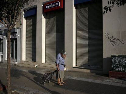 Una mujer pasa delante de una sucursal bancaria cerrada, el lunes en Atenas. 