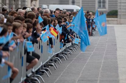 Un grupo numeroso de personas aguarda al paso de la comitiva junto al Palacio Real, este martes en Madrid.