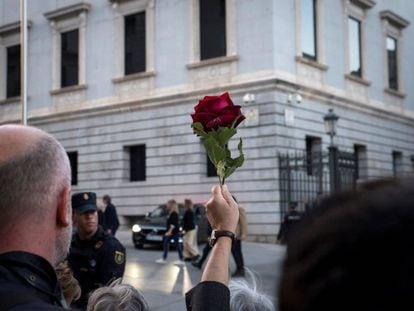 Una persona sujeta una rosa roja durante la llegada del féretro de Alfredo Pérez Rubalcaba, este viernes en el Congreso.