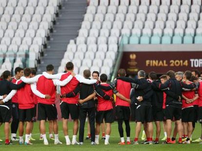 Los jugadores del Sevilla, abrazados en el entrenamiento.