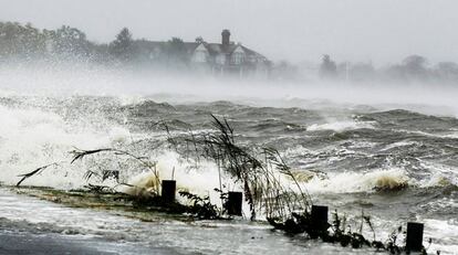 Agua conducida en una carretera por el huracán Sandy saltos sobre una barrera de seguridad en Southampton, Nueva York