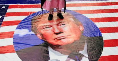 Una niña pisa un cartel de Donald Trump. 