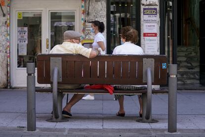 Una pareja de ancianos sentada en un banco.