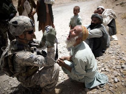 El soldado Brad Parrish, de la 101 División Aerotransportada, toma una fotografía de la dentadura de un campesino afgano, para su identificación.