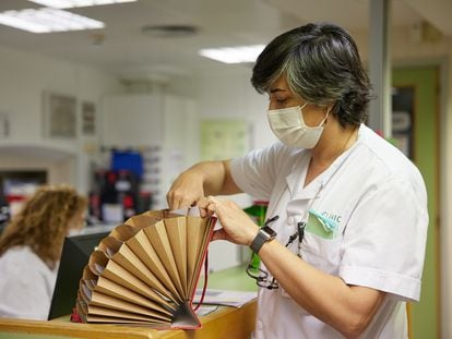 Una trabajadora del hospital Clínic consulta unos archivos durante la caída de los sistemas informáticos.