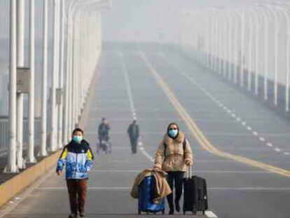 Una madre y su hijo llegan al punto fronterizo de la provincia de Hubei, en el puente Jiujiang, que cruza el río Yangtze. 