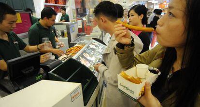 Clientes probando el chocolate con churros en uno de los dos puestos de San Gin&eacute;s en Shangh&aacute;i.