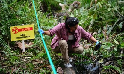 Una mujer muestra una botella cubierta con petróleo, en una imagen de 2013 en la región amazónica de Ecuador.