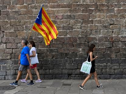 Dos manifestantes a favor de la independencia de Cataluña con una bandera "estelada", durante la Diada, el 11 de septiembre de 2022.