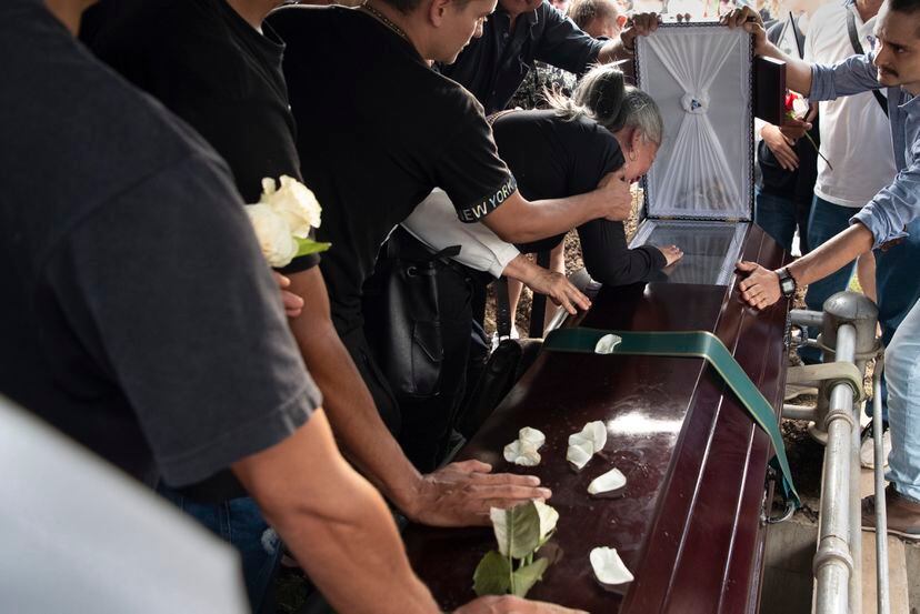 Lucely Marulanda, madre de Esteban Llano Marulanda, llora sobre el féretro de su hijo antes de que éste sea enterrado.