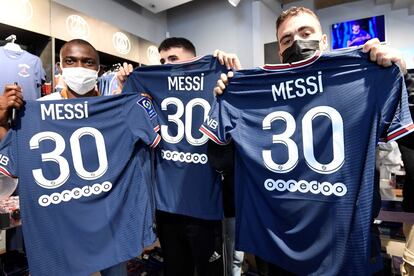 Aficionados del PSG posan con camisetas de Messi, que acaban de comprar en la tienda del club de fútbol París-Saint-Germain (PSG), este miércoles en París.