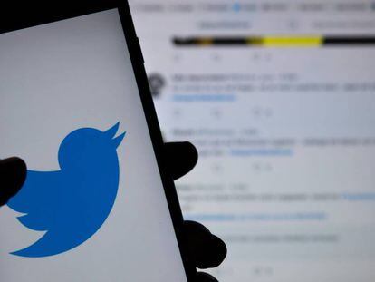El logo de Twitter, en un teléfono móvil frente a una pantalla con la red social.