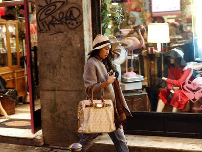 Una mujer pasea frente a un escaparate del barrio madrileño de Malasaña.