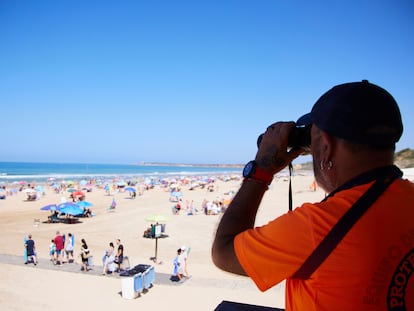 Un vigilante de la playa observa a los bañistas desde su torre en la playa de la Fontanilla en Conil de la Frontera, a 8 de julio de 2023 en Cádiz (Andalucía).