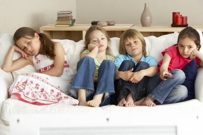 Cuatro niños se aburren en el sillón.