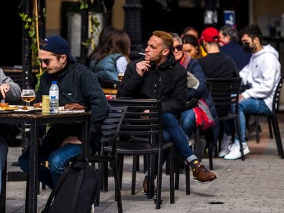 Personas sentadas en febrero en la terraza de un bar en la plaza de Santa Ana, en Madrid.