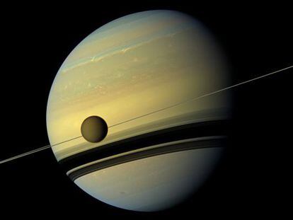 El planeta Saturno y su luna Tit&aacute;n, cruz&aacute;ndose por delante, fotografiados por la sonda espacial &#039;Cassini&#039;.