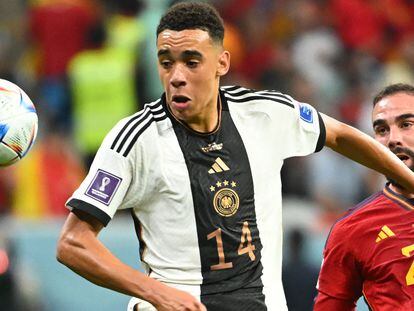 Germany's midfielder #14 Jamal Musiala is challenged by Spain's defender #20 Dani Carvajal during the Qatar 2022 World Cup Group E football match between Spain and Germany at the Al-Bayt Stadium in Al Khor, north of Doha on November 27, 2022. (Photo by Ina Fassbender / AFP)