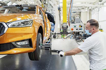 Un trabajador ajusta las ruedas en una planta automovilística de Skoda.