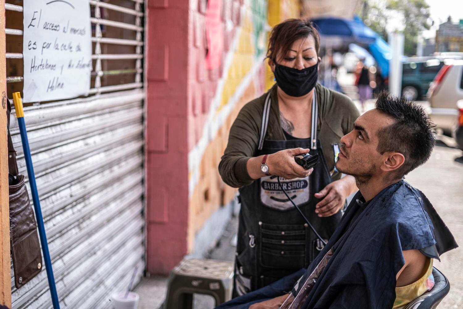 Lilia Martínez corta el cabello al exterior del mercado Morelos, en Ciudad de México.