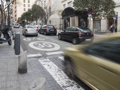 Dos vehículos pasan por una calle del centro de Madrid limitada a 30 kilómetros por hora.