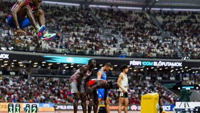 Noah Lyles, a la izquierda, calienta con un salto antes de la salida de los 100m.